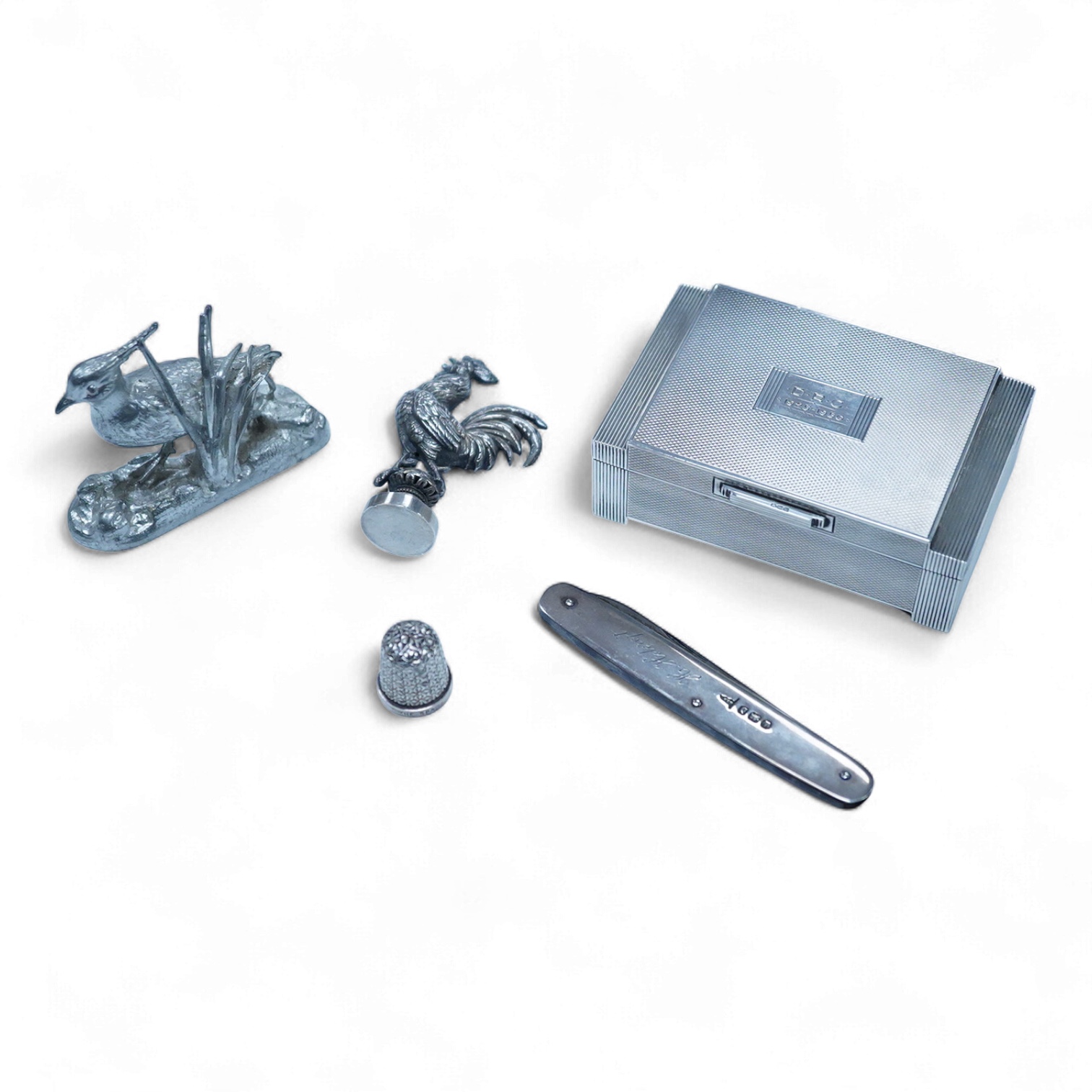 A George VI Art Deco engine turned silver mounted trinket box, by Dudley Russell Howitt, Birmingham, 1947, width 85mm, together with a late Victorian silver fruit knife, a silver thimble, a white metal cockerel mounted s